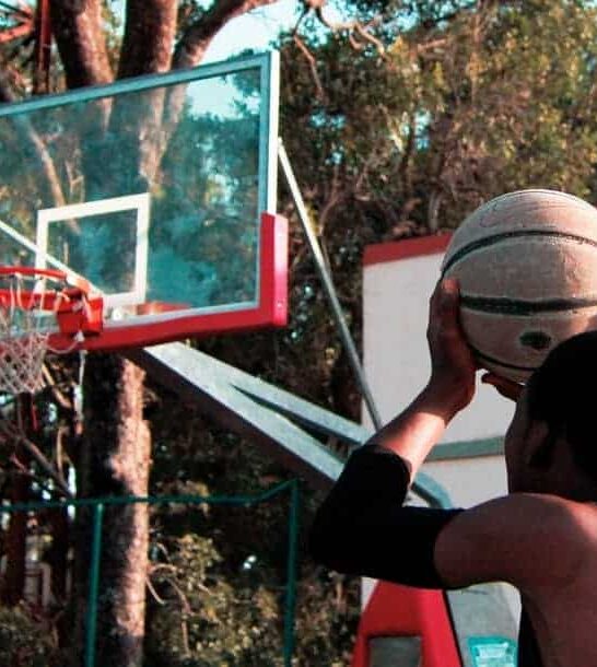 basketball player setting up to shoot the basketball at the rim outside.