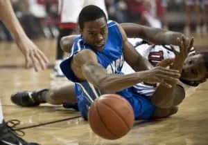 Two players during a game dive for a loose ball.