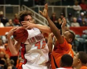 Player being fouled going up for a shot in basketball