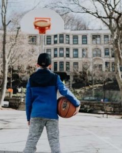 kid with ball staring at basketball hoop